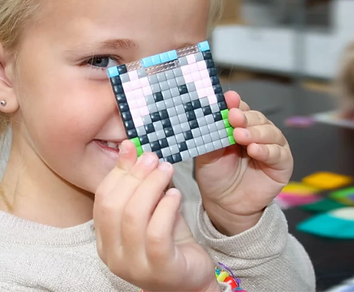 Girl proudly showing the small Pixelhobby artwork she made